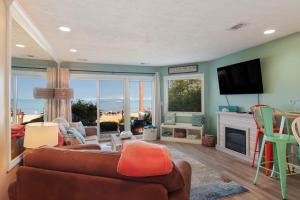 a living room with a couch and a television at Beachside 109 with Direct Beach Access Pool and Hot Tub in Traverse City