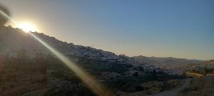 uma vista para uma colina com o pôr-do-sol em Petra Gardens em Wadi Musa