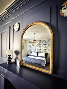 - une chambre avec un grand miroir sur un mur bleu dans l'établissement Maison d'hôte Les Allois, à Limoges