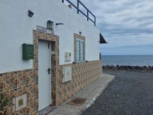 a building with a door on the side of the ocean at Casa Carmen in Castillo del Romeral