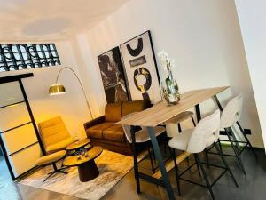 ein Esszimmer mit einem Tisch, Stühlen und einem Sofa in der Unterkunft Der Vitihof Loft in Osnabrück