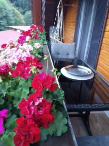 een balkon met bloemen, een tafel en een stoel bij Ferienwohnung Sonnenblick in Oberharmersbach