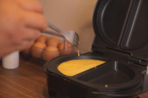 a person is pouring sauce into a pot of food at Pousada Calza - Vale dos Vinhedos - Bento Gonçalves in Bento Gonçalves