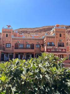 un bâtiment avec une montagne en arrière-plan dans l'établissement Kasbah La Famille Berbère, à Boumalne