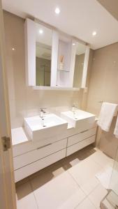 a bathroom with two sinks and two mirrors at iTowers Studio-Suite in Gaborone