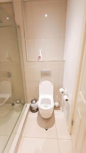 a white bathroom with a toilet and a sink at iTowers Studio-Suite in Gaborone