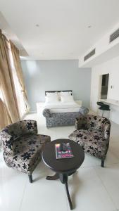 salon ze stołem, 2 krzesłami i łóżkiem w obiekcie iTowers Studio-Suite w mieście Gaborone
