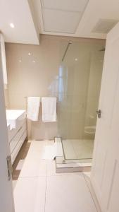 a bathroom with a glass shower with towels on it at iTowers Studio-Suite in Gaborone