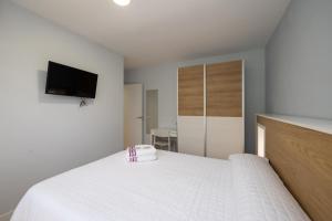 A television and/or entertainment centre at ALQUILAZ Apartamentos Turísticos