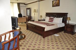a bedroom with a bed and a desk and a television at Hotel Karisimbi in Kigali