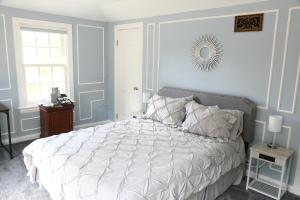 高地公園的住宿－Luxury Suite at Private Beach North Shore Residence，卧室配有白色的床和墙上的镜子