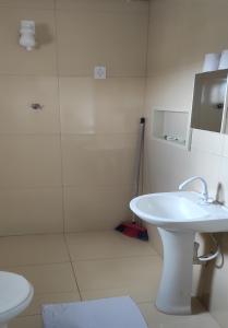 W łazience znajduje się biała umywalka i prysznic. w obiekcie Pousada Ramon w mieście Remígio
