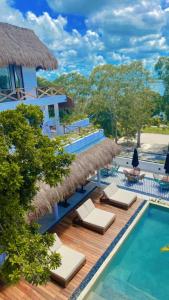 a resort with a swimming pool with chaise lounge chairs at Hotel Sun Ha Bacalar in Bacalar