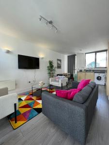 a living room with a gray couch and a colorful rug at Chertsey - Beautiful Modern 2 Bedroom Apartment in Chertsey