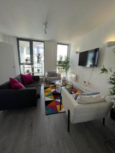 uma sala de estar com 2 sofás e uma televisão de ecrã plano em Chertsey - Beautiful Modern 2 Bedroom Apartment em Chertsey