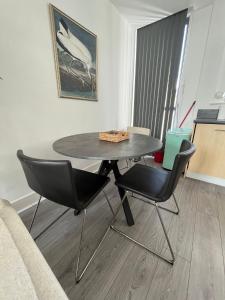 a table and chairs in a living room with a couch at Chertsey - Beautiful Modern 2 Bedroom Apartment in Chertsey