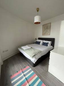 a small bedroom with a bed and a rug at Chertsey - Beautiful Modern 2 Bedroom Apartment in Chertsey