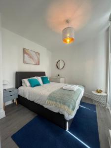 a bedroom with a large bed with a blue rug at Chertsey - Beautiful Modern 2 Bedroom Apartment in Chertsey