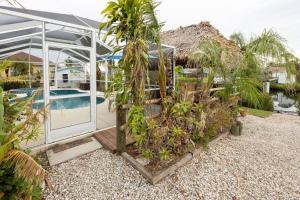 uma estufa com palmeiras e uma piscina em Avonsdale Cir Pool and Tiki Hut Home in Port Charlotte 33948 em Port Charlotte