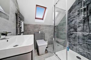 a bathroom with a toilet and a sink and a shower at Luxury House with Pool Table, Sky TV, Netflix, Fast Wifi, Garden & Free Parking by Yoko Property in Milton Keynes