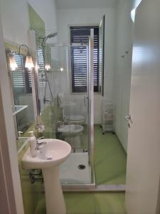 フォンターネ・ビアンケにあるLa Sorgenteのバスルーム(ガラス張りのシャワー、シンク付)