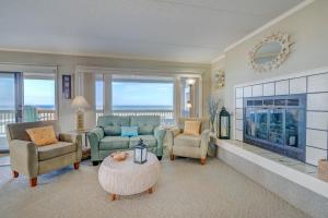 a living room with a fireplace and a couch and chairs at 5737 - Diamond by the Sea by Resort Realty in Nags Head