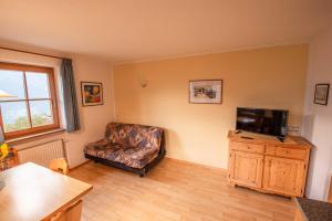 a living room with a chair and a flat screen tv at Patztauhof in Sluderno