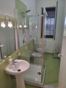 フォンターネ・ビアンケにあるLa Sorgenteのバスルーム(洗面台、ガラス張りのシャワー付)