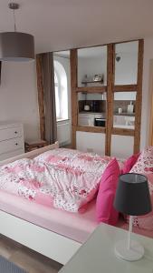 a bedroom with a bed with pink sheets and a table at Ferienwohnung Kaffestübchen 