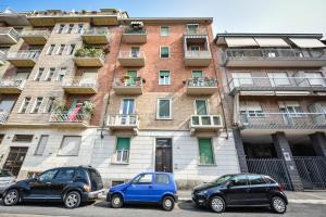 deux voitures garées devant un bâtiment dans l'établissement Benvenuti Casa Leo - Elegante Appartamento, à Turin