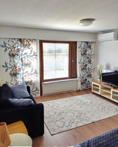 sala de estar con sofá y ventana en RT asunto, sauna, terassi ja autokatos, en Jalasjärvi