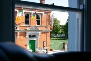 una ventana con banderas frente a un edificio de ladrillo en No 1 St George’s Terrace. en Carrick on Shannon