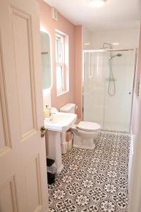 een badkamer met een toilet, een wastafel en een douche bij No 1 St George’s Terrace. in Carrick on Shannon