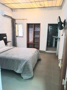 - une chambre avec un lit, une fenêtre et un lavabo dans l'établissement Hotel du Golfe de Guinée, à Conakry