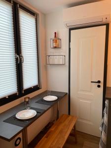 two sinks on a counter in a room with a door at Tiny House im Spreewald in Kittlitz