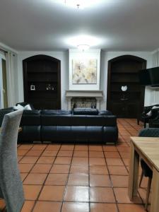 a living room with a black couch and a fireplace at A Flor da Rosa in Vila Nova de Foz Coa