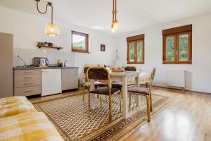 a kitchen and dining room with a table and chairs at Apartmani Jelenača prizemlje in Trnovo