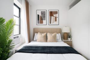 biała sypialnia z łóżkiem z poduszkami w obiekcie 444-3A Newly renovated 1BR - Elevator Building w Nowym Jorku