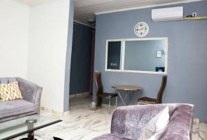 een woonkamer met een bank en een tafel bij Le relax in Bonamoussadi