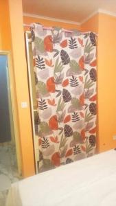 een slaapkamer met een gordijn met sinaasappels en vlinders erop bij Le relax in Bonamoussadi