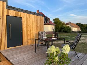 een patio met een tafel en stoelen op een houten terras bij Tiny House im Spreewald in Kittlitz