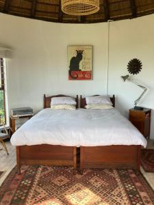 a bedroom with a large bed with white sheets at Rondawel with sea view in Kleinmond