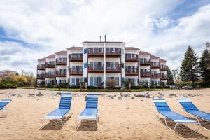 a row of beach chairs on the sand in front of a hotel at Beach 321 with Vaulted Ceilings Pool Hot Tub and Stunning Views from Private Deck in Traverse City
