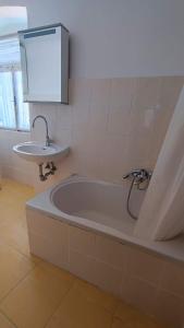 a bathroom with a bath tub and a sink at Altana Rooms in Koper