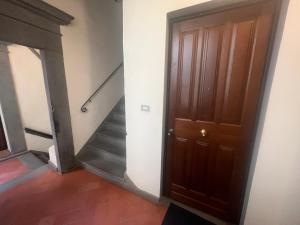 korytarz z drewnianymi drzwiami i schodami w obiekcie AL 106 Apartment [Free Wi-fi 5 min dalla Stazione] w mieście Prato