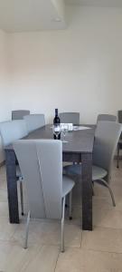 stół jadalny z krzesłami i butelkę wina w obiekcie Ferienwohnung Stoisser w mieście Mureck