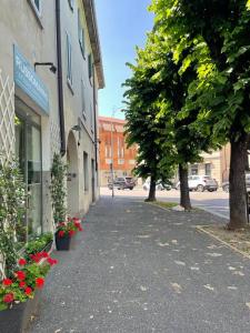 une rue de la ville avec un bâtiment et des fleurs sur le trottoir dans l'établissement Kiko's Lodge - Historical apartment in Como, à Côme