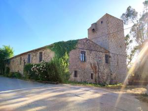 an old brick building with ivy growing on it at Mas Fina in Palafrugell