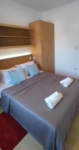 a large bed with two pillows on top of it at Apartman 77 in Požarevac