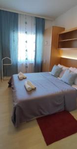 a bedroom with a large bed with two towels on it at Apartman 77 in Požarevac